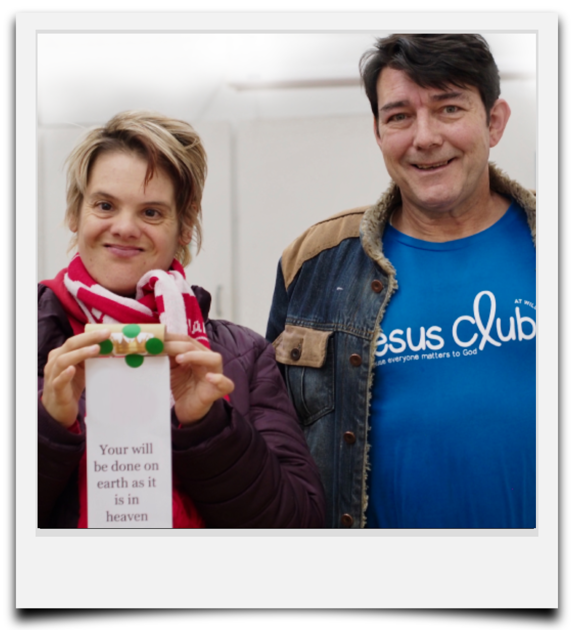 Two Jesus Club members smiling at camera. One is holding up his Christmas craft.